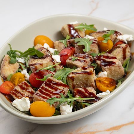 Crispy eggplant salad with arugula, cherry tomatoes, goat cheese and a dark glaze